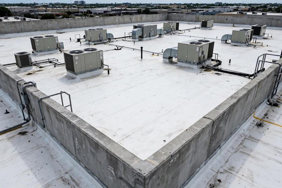 Flat commercial roof with white membrane and rooftop units
