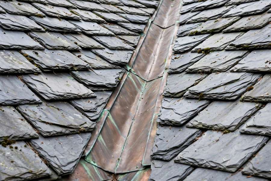 Natural slate roof tiles with copper flashing at a valley